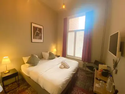 a bedroom with a bed and a window at Simone's Kitchen B&B in Antwerp