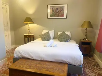 a bedroom with a white bed with two lamps at Simone's Kitchen B&B in Antwerp