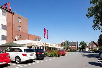a city street with cars parked in a parking lot at Vivaldi Hotel in Westerlo