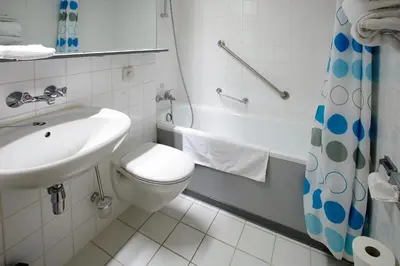 a bathroom with a sink and a toilet and a tub at Vivaldi Hotel in Westerlo