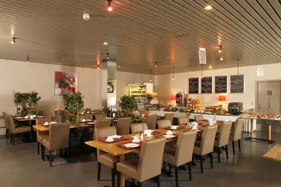 a dining room with tables and chairs in a restaurant at Vivaldi Hotel in Westerlo
