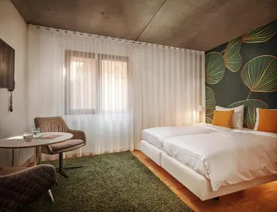 a bedroom with a bed and a table and a chair at BANKS Antwerp in Antwerp