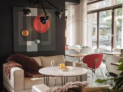a living room with a couch and tables and chairs at BANKS Antwerp in Antwerp