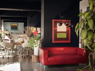 a red couch in a room with a dining room at BANKS Antwerp in Antwerp