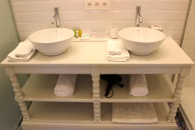 two sinks on a table in a bathroom with towels at The Hamptons Boutique Hotel in Ghent