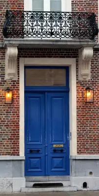 a blue door on a brick building at The Hamptons Boutique Hotel in Ghent