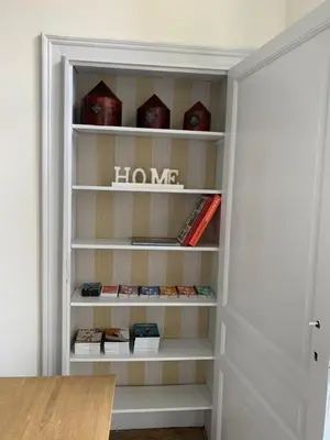 a closet with a door open with books at The Hamptons Boutique Hotel in Ghent