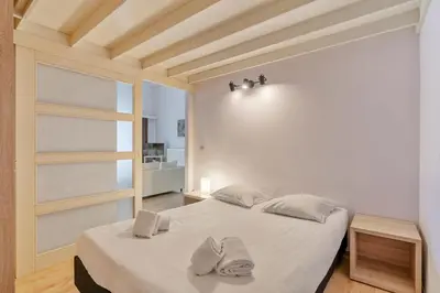 a bedroom with a bed with two slippers on it at Ambassador Suites Leuven in Leuven