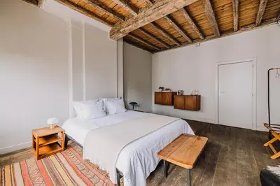 a bedroom with a white bed and a wooden table at Burgstraat 8 in Ghent