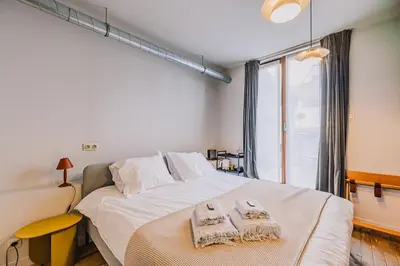 a bedroom with a large bed with towels on it at Burgstraat 8 in Ghent