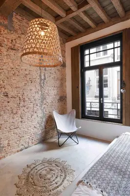 a room with a chair and a chandelier at Boutique Holiday Home Zalig In Antwerpen in Antwerp
