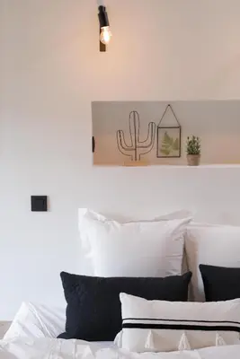 a bed with white pillows and a cactus on the wall at Boutique Holiday Home Zalig In Antwerpen in Antwerp