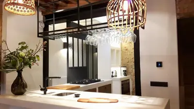 a kitchen with two chandeliers above a sink and a counter at Boutique Holiday Home Zalig In Antwerpen in Antwerp