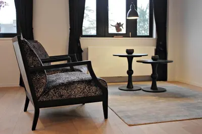 a chair and a table in a room with a window at B&B VIENNA in Lokeren