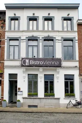 a white building with a sign on the front of it at B&B VIENNA in Lokeren