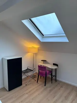 a skylight in a room with a table and a chair at Hotel Albert in Brussels