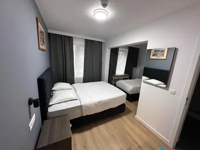 a small bedroom with two beds and a mirror at Hotel Albert in Brussels