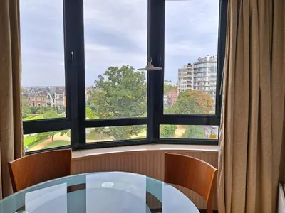 a table and chairs in front of a large window at B-aparthotel Ambiorix in Brussels