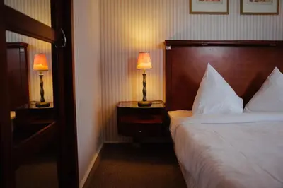 a hotel room with a bed and two lamps on tables at B-aparthotel Ambiorix in Brussels