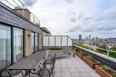 a balcony with tables and chairs on a building at B-aparthotel Ambiorix in Brussels