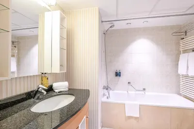a bathroom with a sink and a bath tub at B-aparthotel Ambiorix in Brussels