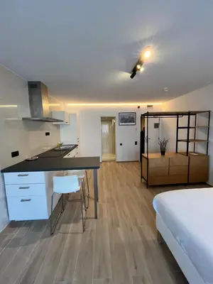 a kitchen and a bedroom with a bed and a desk at B-aparthotel Montgomery in Brussels