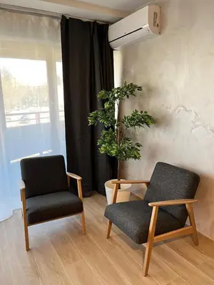 two chairs and a table in a room with a plant at B-aparthotel Montgomery in Brussels
