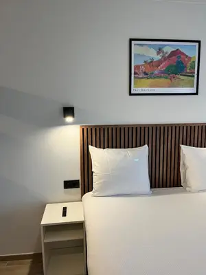 a bedroom with a bed with a nightstand next to it at B-aparthotel Montgomery in Brussels