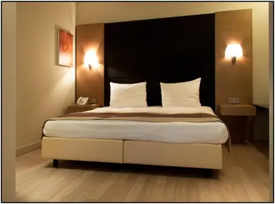 a bedroom with a large bed with a black headboard at B-aparthotel Montgomery in Brussels