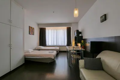 a small room with two beds and a couch at Budget Flats Antwerp in Antwerp