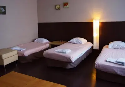 a hotel room with three beds and a lamp at Budget Flats Antwerp in Antwerp