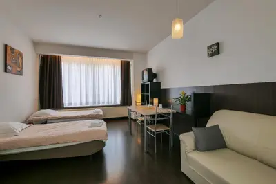 a room with two beds and a couch and a table at Budget Flats Antwerp in Antwerp