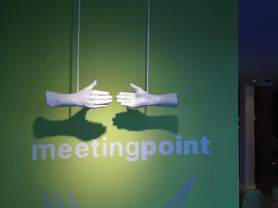 a sign for a meeting point with two hands at Hotel Corbie Geel in Geel