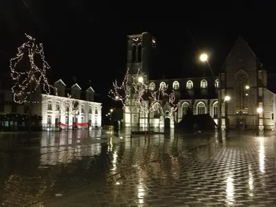 a large building with lights in front of it at night at Hotel Corbie Geel in Geel