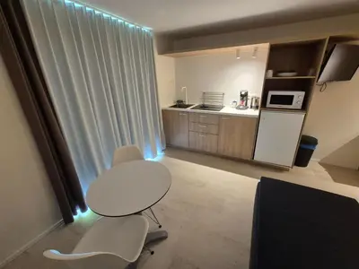 a kitchen with a table and two chairs in a room at Hotel Corbie Geel in Geel