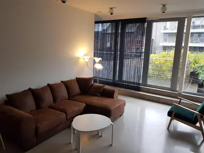 a living room with a brown couch and a table at Hotel Corbie Geel in Geel
