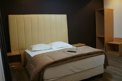 a bedroom with a large bed with a headboard at Hotel Evergreen in Brussels