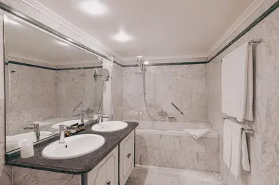 a bathroom with two sinks and a bath tub at Hotel Manos Premier in Brussels