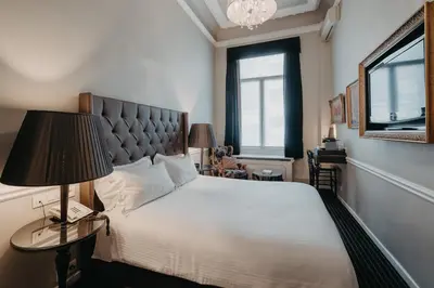 a bedroom with a bed and a lamp and a window at Hotel Manos Premier in Brussels