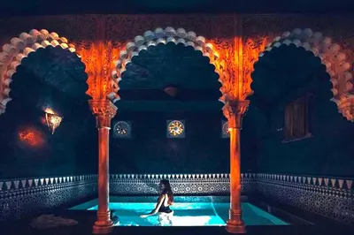 a woman sitting in a pool in a room with columns at Hotel Manos Premier in Brussels