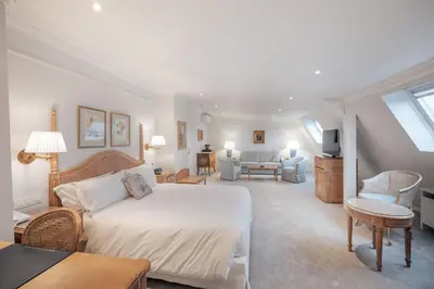a bedroom with a large bed and a living room at Hotel Manos Stephanie in Brussels