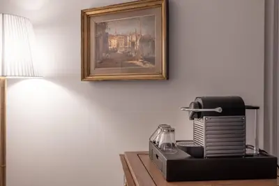 a black toaster sitting on a table with a picture at Hotel Manos Stephanie in Brussels