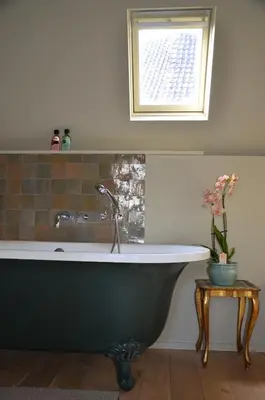 a bath tub in a bathroom with a window at B&B De Vrome Vos in Mechelen