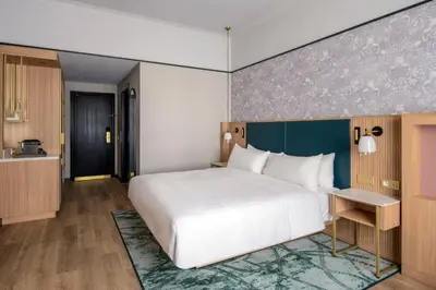 a bedroom with a large bed and a kitchen at Brussels Marriott Hotel Grand Place in Brussels