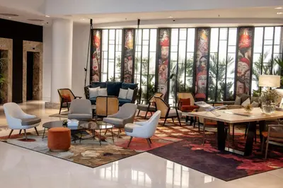 a lobby with chairs and a table and windows at Renaissance Brussels Hotel in Brussels