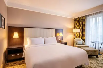 a hotel room with a large bed and a chair at Renaissance Brussels Hotel in Brussels