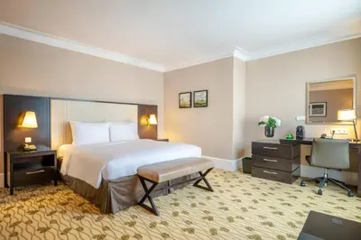 a hotel room with a large bed and a desk at Renaissance Brussels Hotel in Brussels