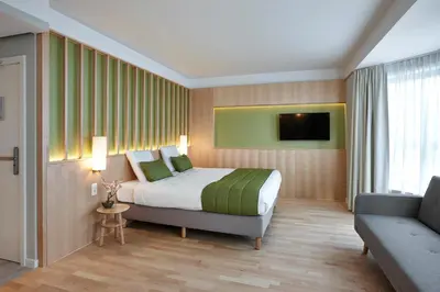a hotel room with a bed and a couch at Yadoya Hotel in Brussels