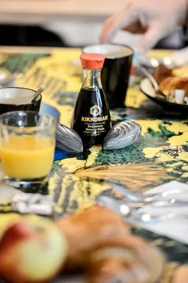 a bottle of sauce sitting on a table with food at Yadoya Hotel in Brussels