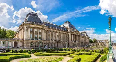 a large building with a garden in front of it at Yadoya Hotel in Brussels